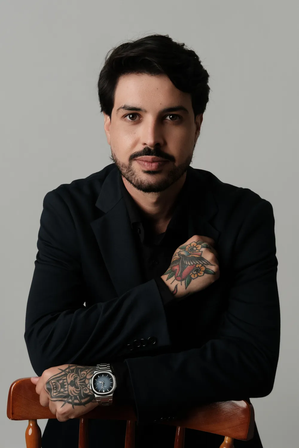 Dr. Jonas Ferro de blazer escuro, com os braços apoiados no encosto de uma cadeira