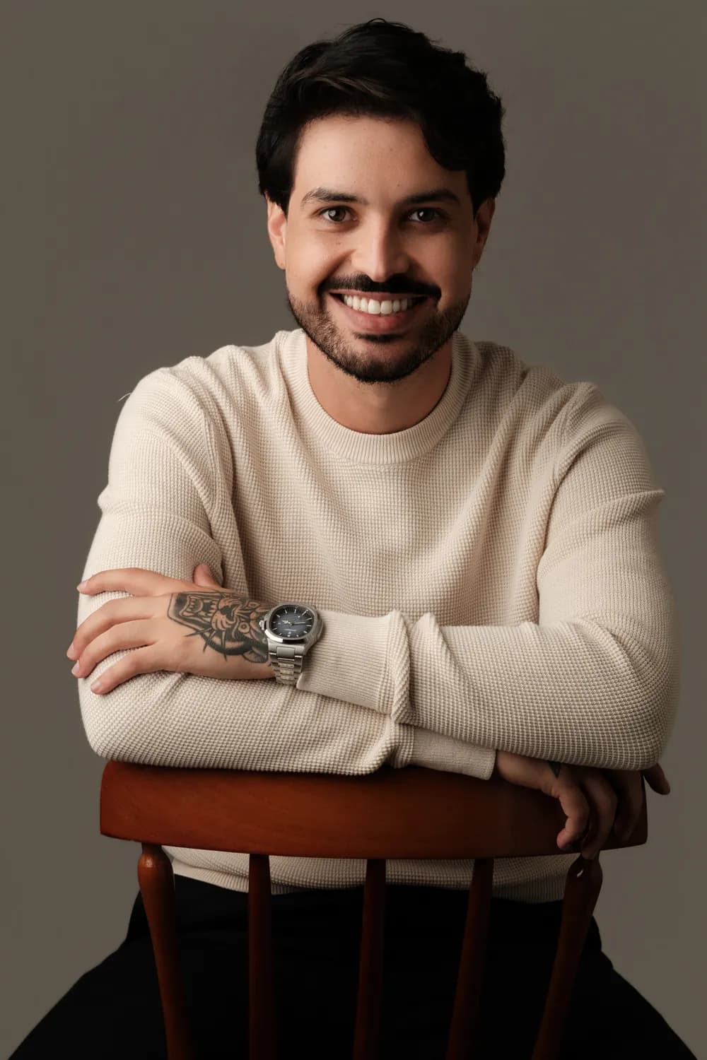 Dr. Jonas Ferro sorrindo, com os braços apoiados no encosto de uma cadeira